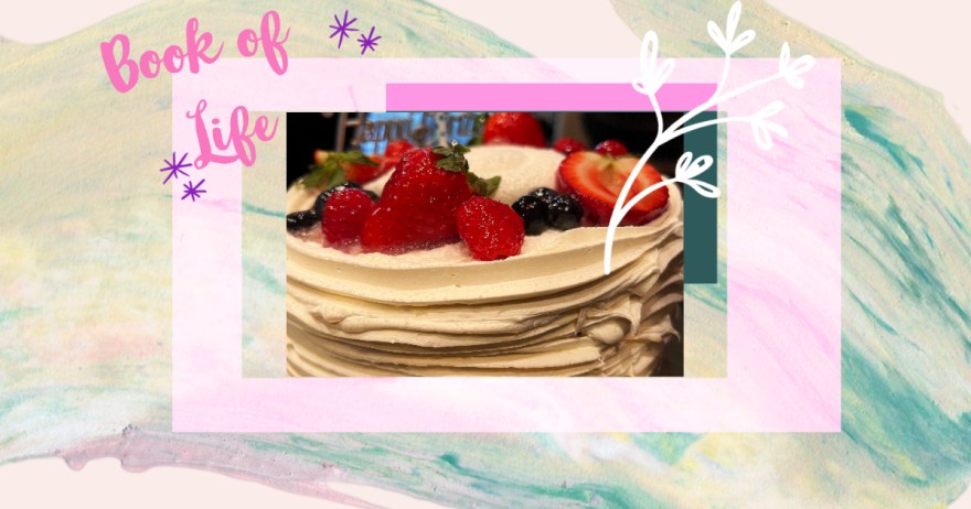 A birthday cake surrounded by borders with words “Book of Life